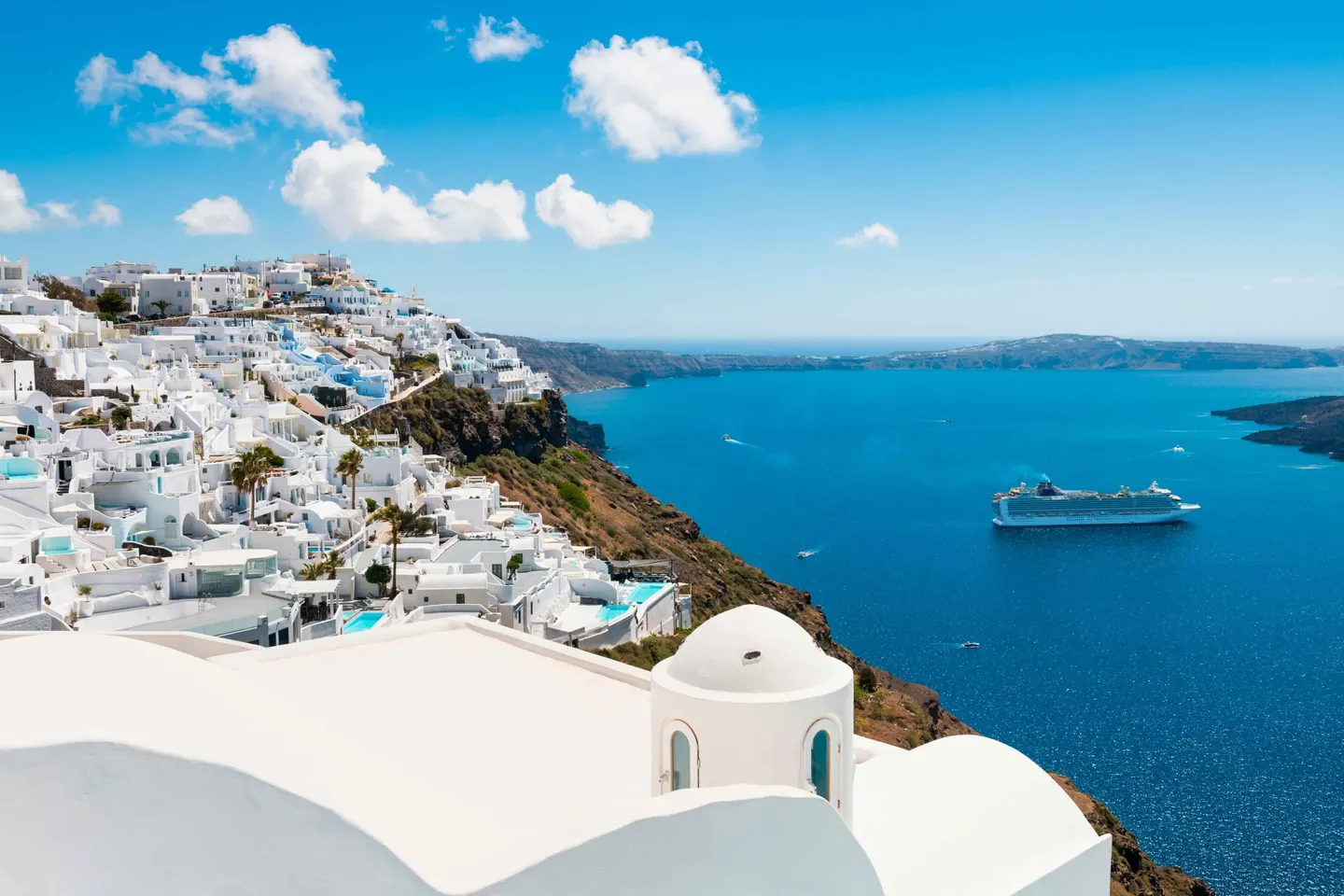 Crucero frente a una isla de Grecia con casas blancas y mar Egeo